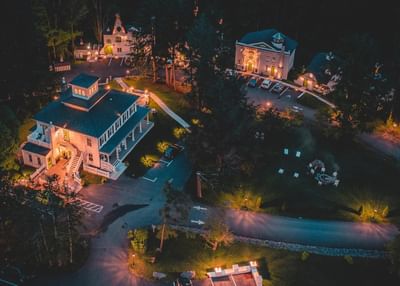 Aerial view of The Roxbury at night featuring buildings, pathways, and a circular gathering area