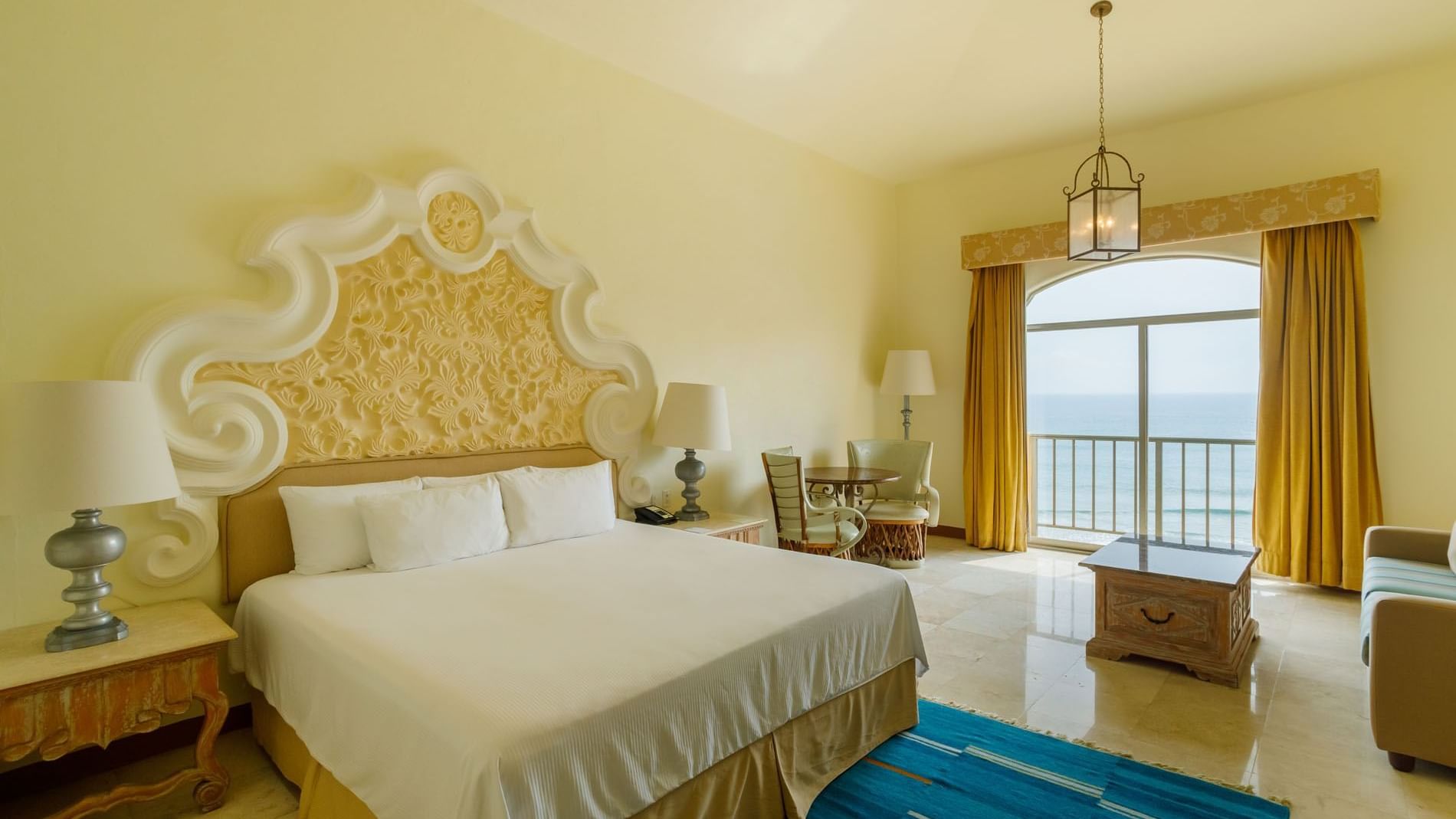 King Presidential Suite at Quinta Real Acapulco, featuring a blue rug, king bed, and a large window overlooking the sea