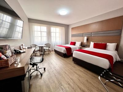 Business Carlton Twin featuring two beds, a work desk, and windows at Dann Carlton Cali, a 5 star hotel in Cali Colombia