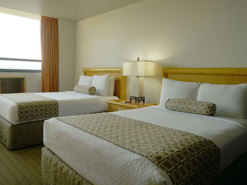 Twin comfy beds and nightstand in Superior Room at Gamma Hotels