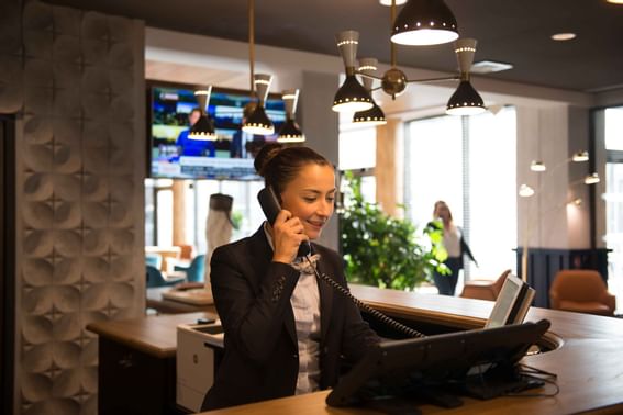 Female receptionist having a phone call at Kopster Hotel Lyon