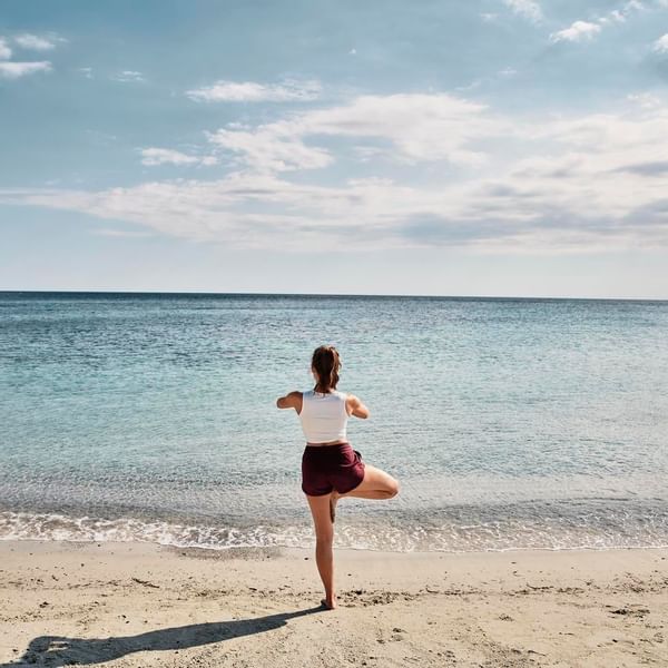 A woman exercising on the beach near Falkensteiner Hotels