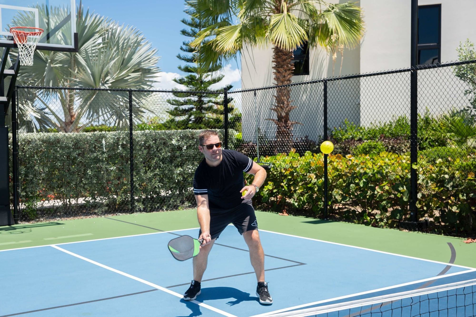 A guest playing pickleball on the on-site court at H2O life.style.resort, Long Bay Beach, Turks and Caicos