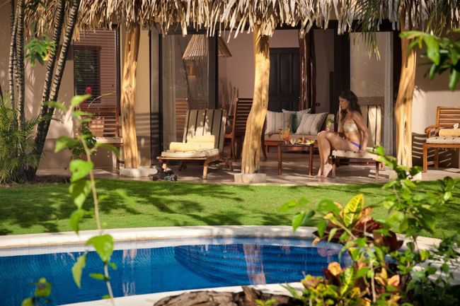 Relaxing poolside terrace featuring a thatched roof and comfortable lounge chairs at Cala Luna Boutique Hotel