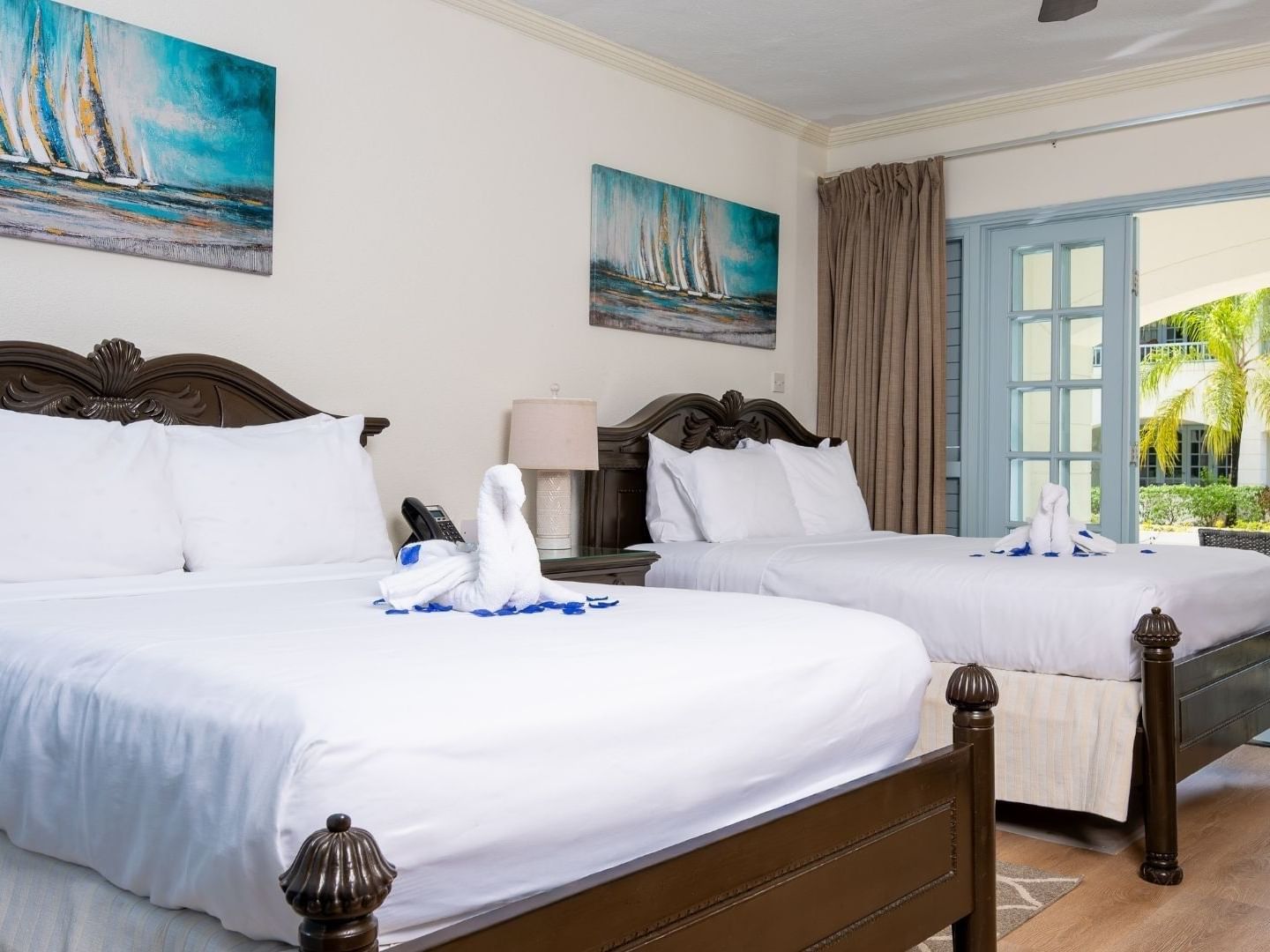 Two twin beds with towels folded in swan shapes at Savannah Beach Hotel.