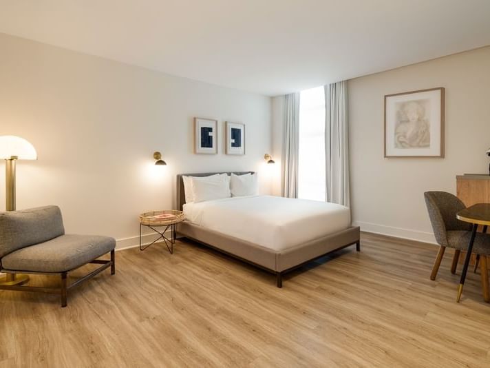 Bedroom Queen with a lounge chair and work table at Kenmore Village Hotel, showcasing art deco hotels, Miami, FL style