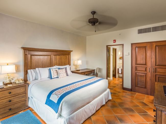 Bedroom with king bed wooden furniture and en suite bathroom inside the Three Bedroom Villa at Hacienda Del Mar Los Cabos