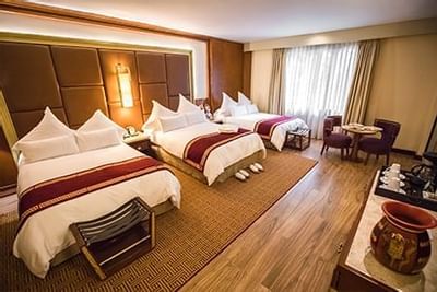 Interior of a family room with three beds at Hotel Sumaq