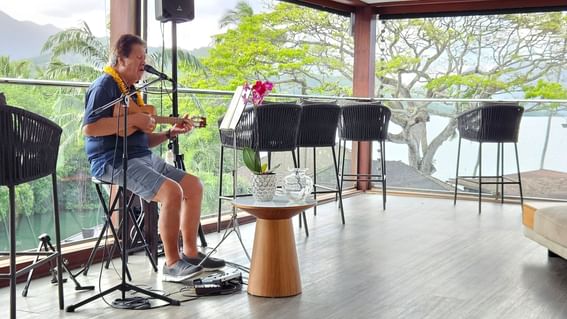 Man singing while playing the guitar in the lobby at Paradise Bay Resort