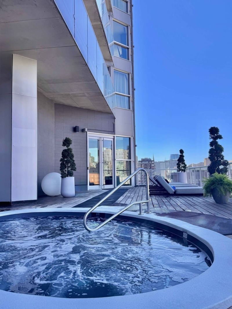 Rooftop hot tub and sun deck with city skyline views at Warwick Le Crystal Montreal
