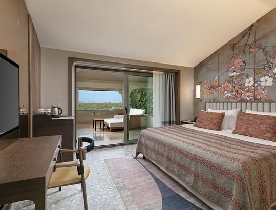 TV facing the bed in Roof Superior Room with floral wall art at Cullinan Belek