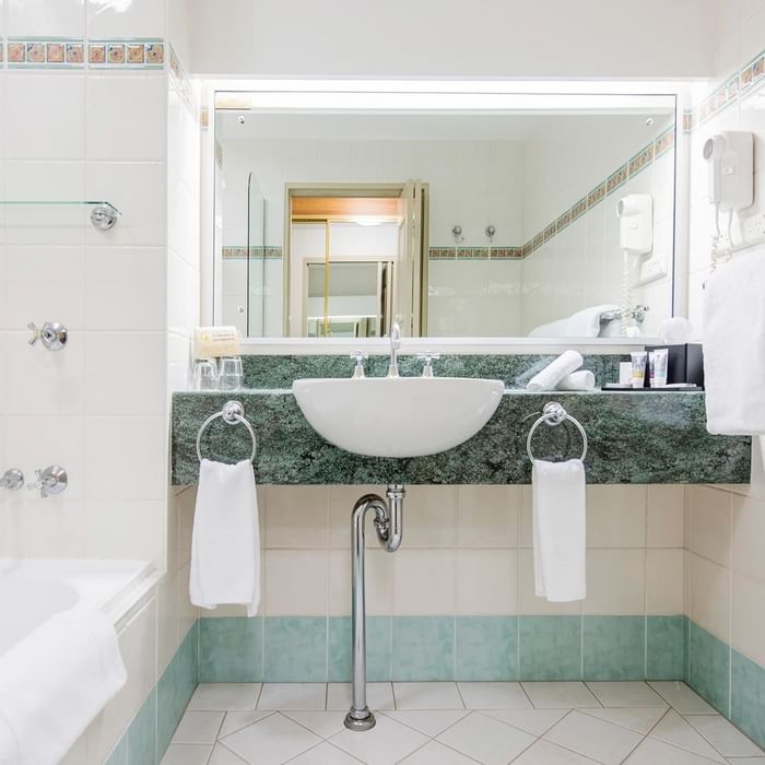 Marbled vanity area by the bathtub in Standard Twin Room bathroom at Mercure Charlestown