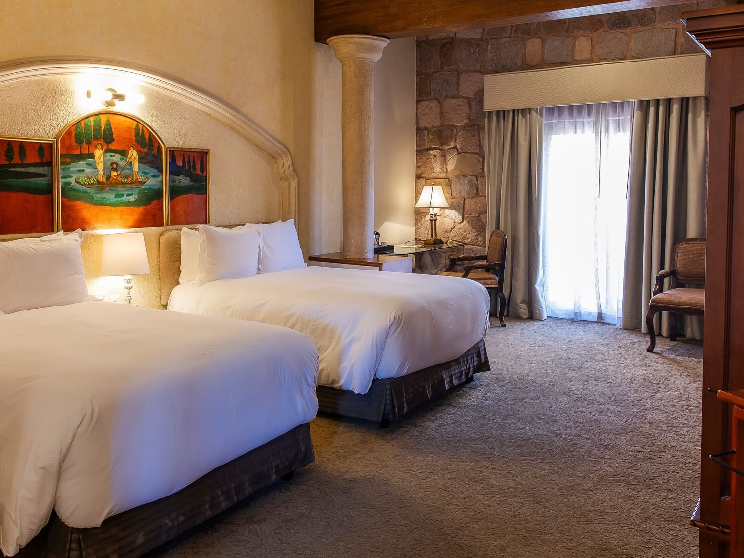 Spacious room with two double beds, stone archway, exposed beam ceiling, and colonial decor at Quinta Real Zacatecas