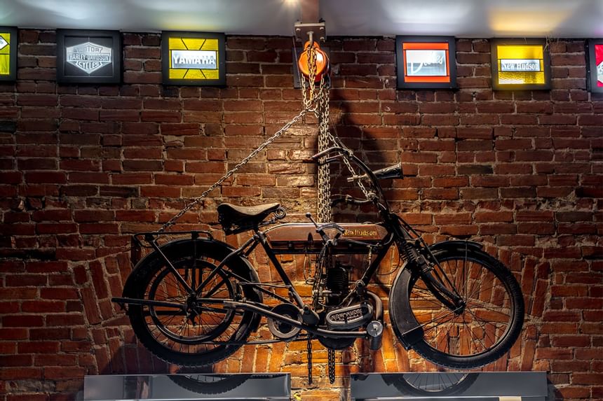 Vintage motorbike hung on a metal chain in Queen Premiere Easy Rider at Retro Suites Hotel