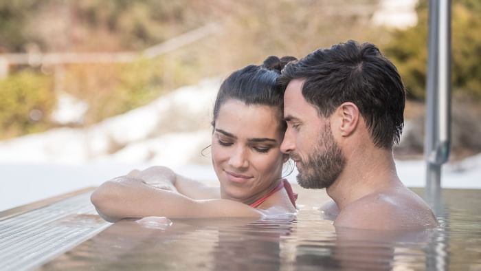 A couple relaxing in the pool at Falkensteiner Hotels