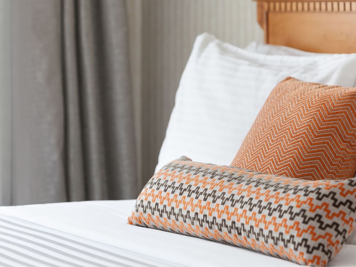 A queen bed with patterned pillows.