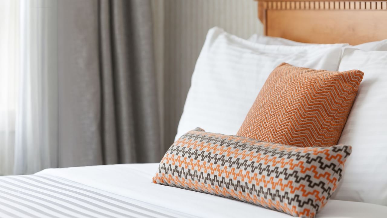 A queen bed with patterned pillows.