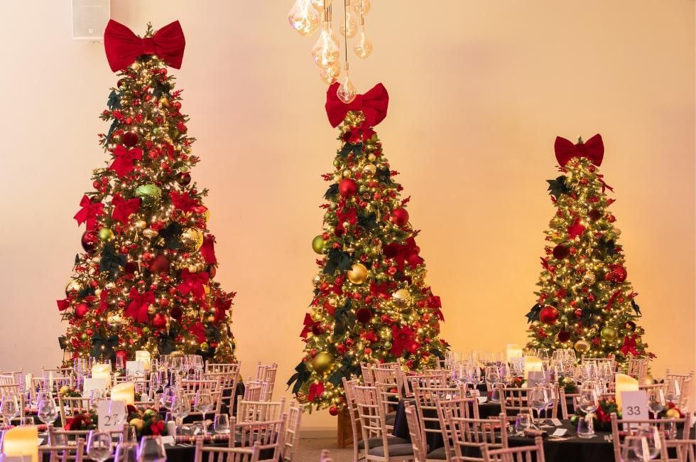 Festive trees and tables at Christmas party night at Easthampstead Park in Berkshire
