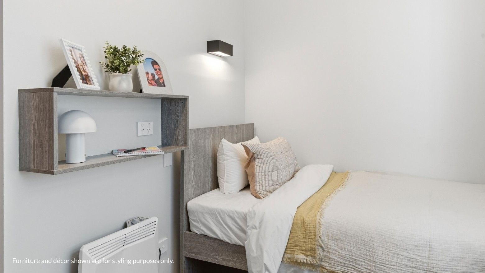 Bedroom with bed, pillow, lamp, and plant on shelf at Mayoral Drive Student Accommodation.