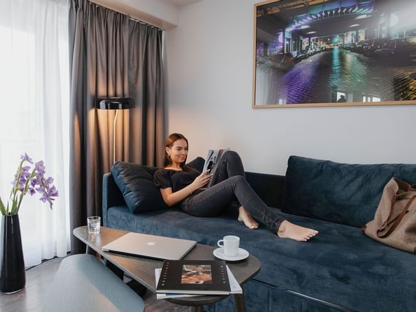 A lady reading a magazine on a lounge at Hotel Berlin Berlin