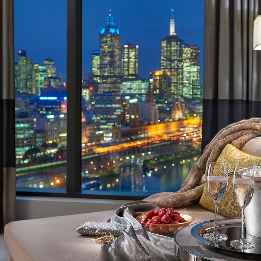 Room with a city view & wine glasses at Crown Hotel Melbourne