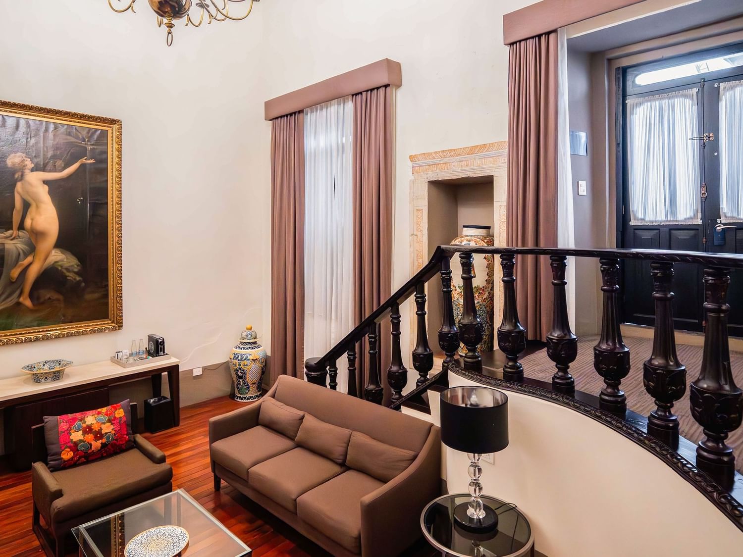 Sala de estar elegante con sofá y pintura en Suite Presidencial King de Quinta Real Puebla en Heroica Puebla de Zaragoza