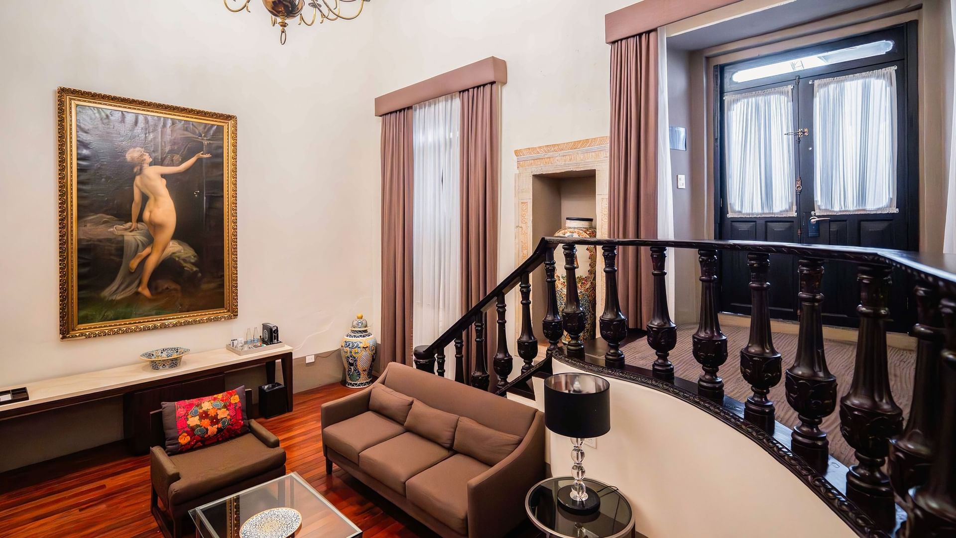 Sala de estar elegante con sofá y pintura en Suite Presidencial King de Quinta Real Puebla en Heroica Puebla de Zaragoza