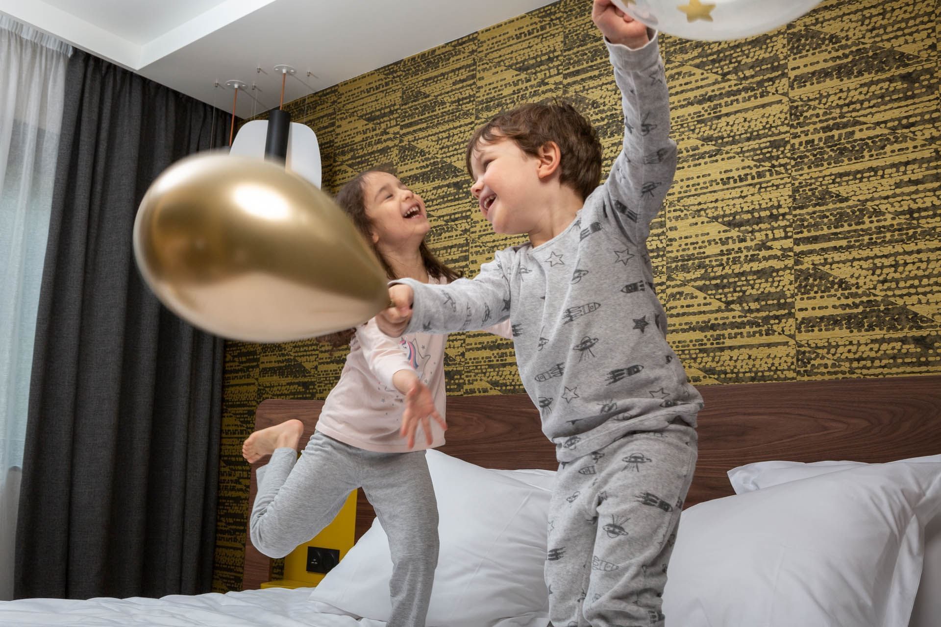 Enfants jouant sur le lit à l'Oceania Paris Porte de Versailles