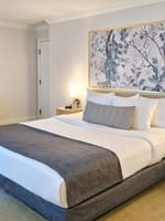 Bed with side tables near work desk in Accessible King Room at Warwick Allerton Chicago