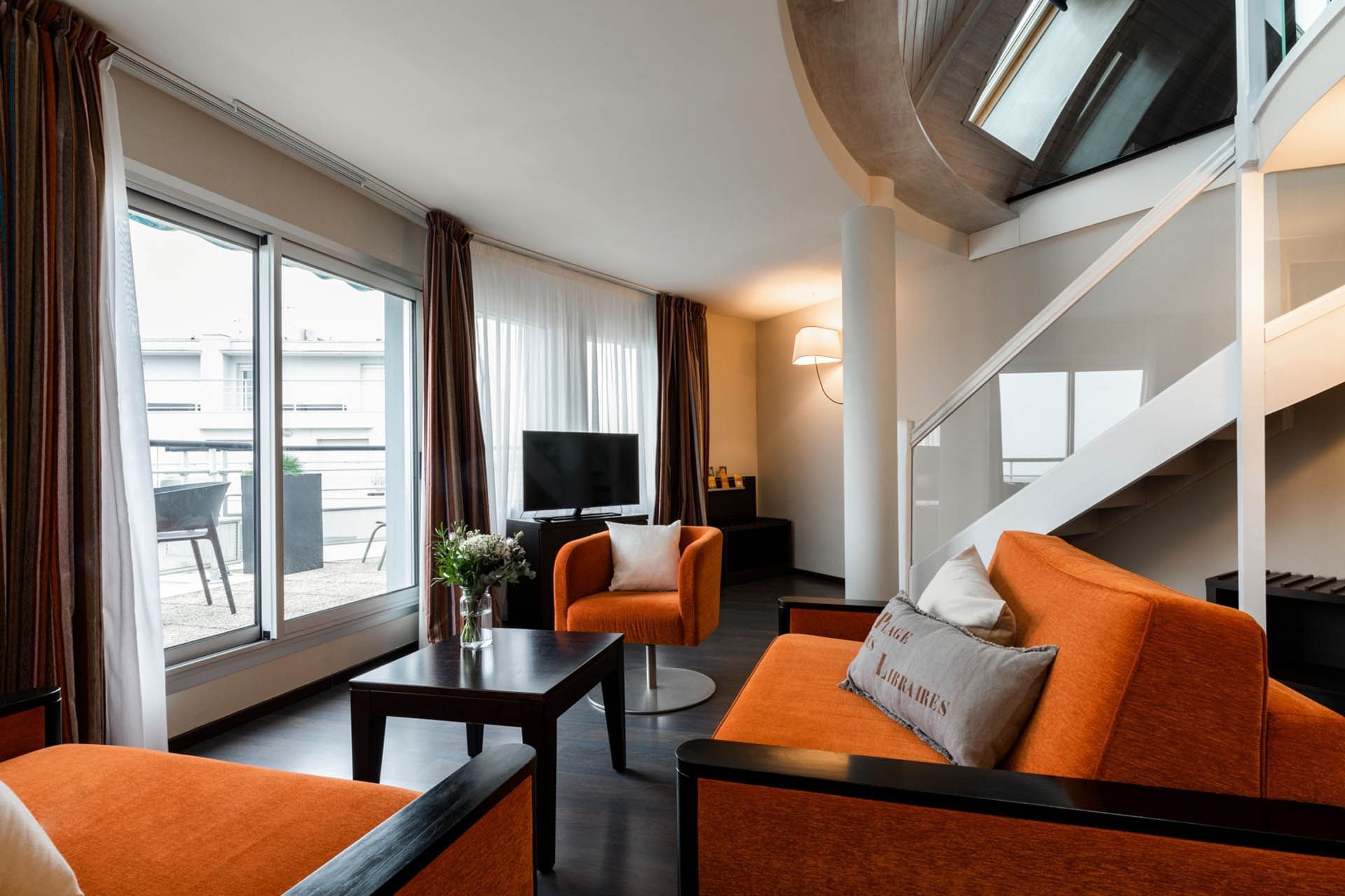 Salon avec canapés, TV et tables, Escale Oceania Pornichet