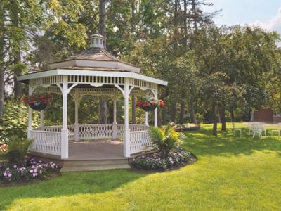 Octagonal garden gazebo surrounded by lush green lawn and trees at Spencer Hotel & Conference Centre