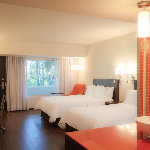 Interior of a room with twin beds and desk at Fiesta Inn