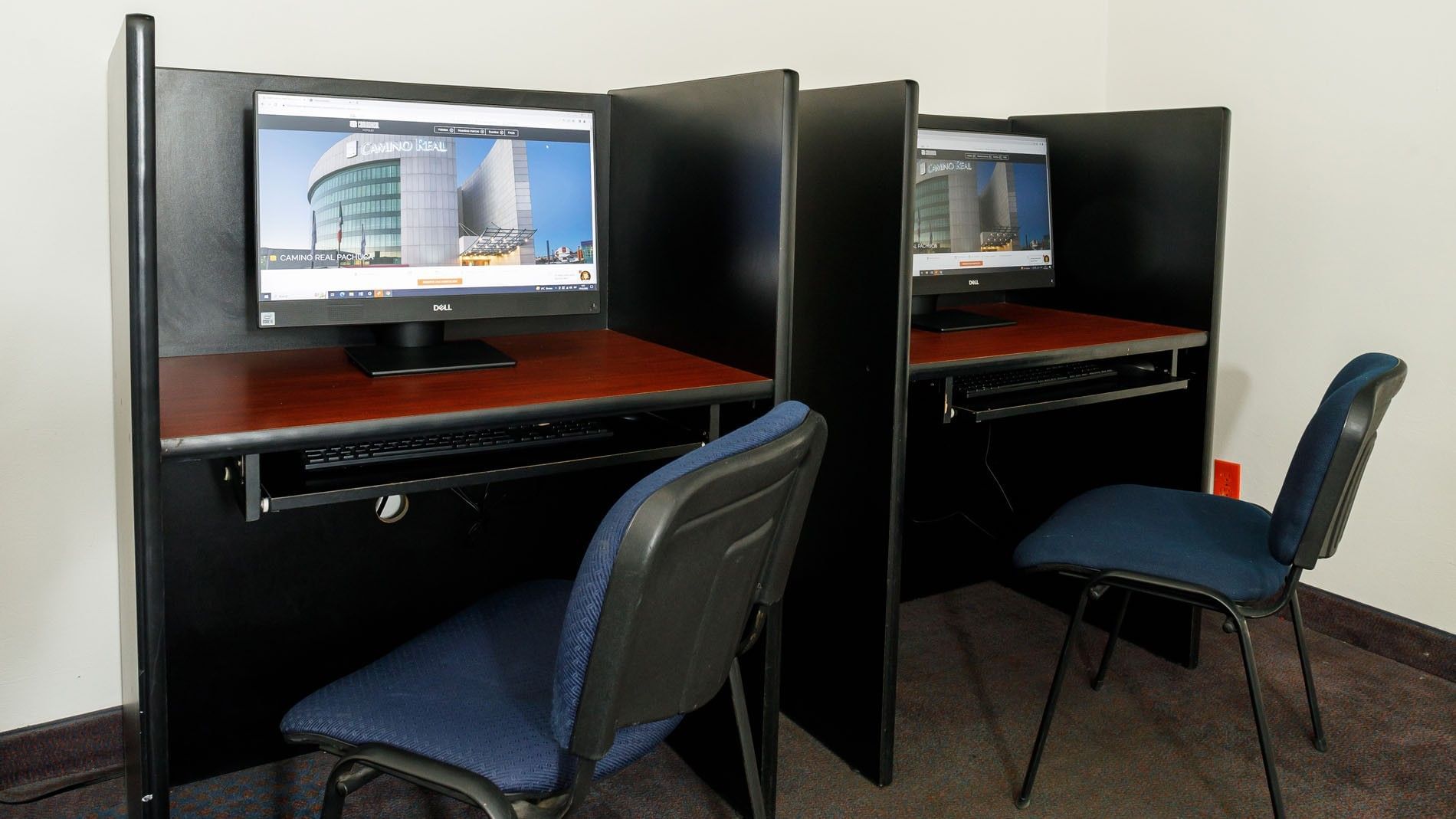 Quiet business center featuring private computer cubicles and ergonomic chairs at Camino Real Pachuca