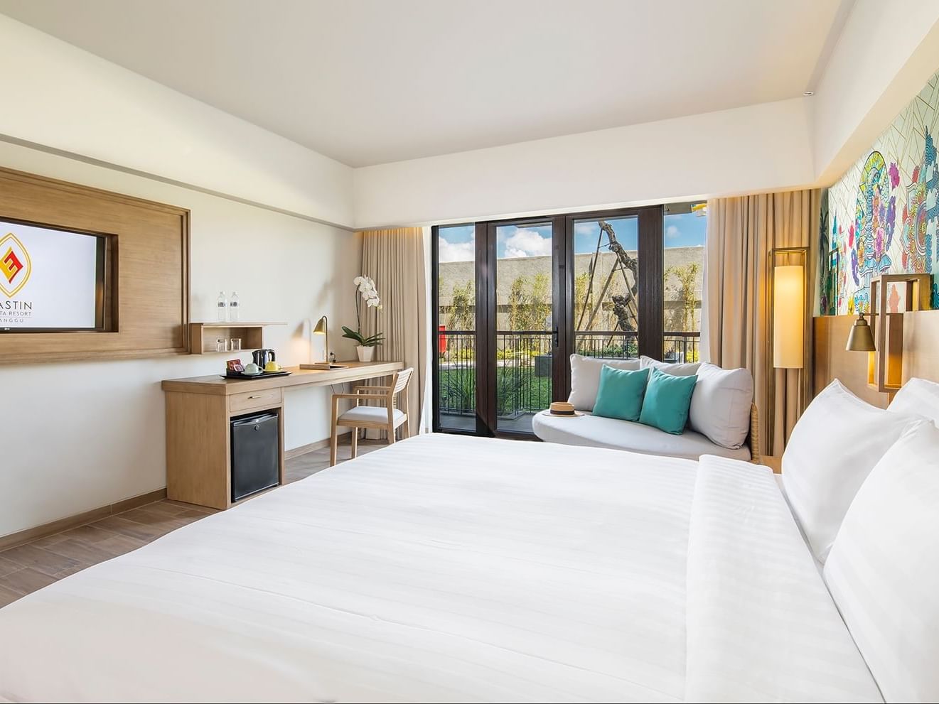 Deluxe Room with a comfy bed and TV area at Eastin Ashta Resort Canggu