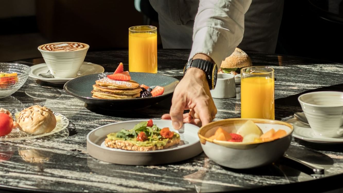 Waiter setting the table for breakfast in a Restaurant at Almanac Barcelona