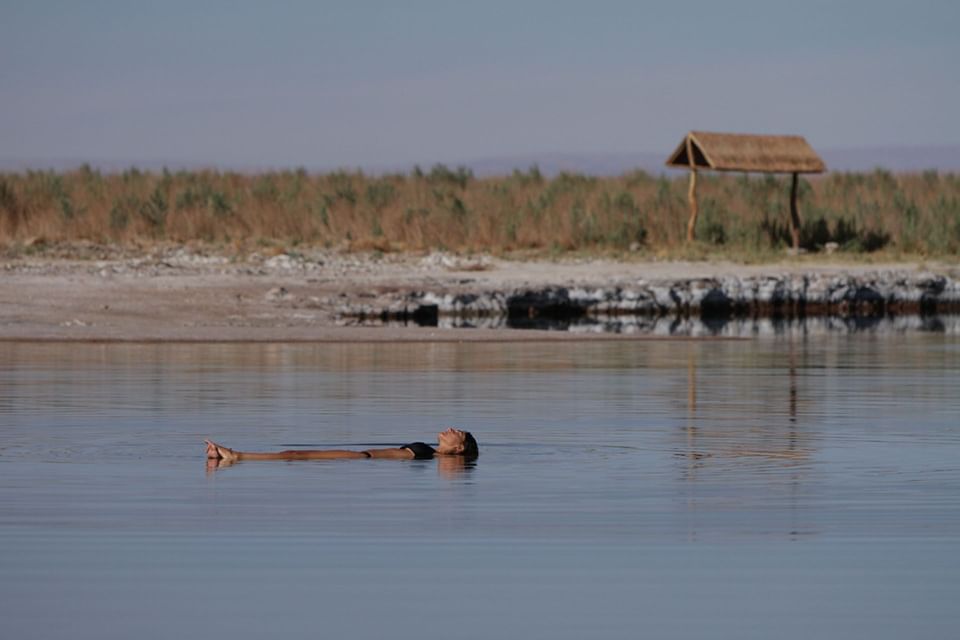 Mujer relajándose en aguas termales con paisaje natural al fondo de Cumbres San Pedro