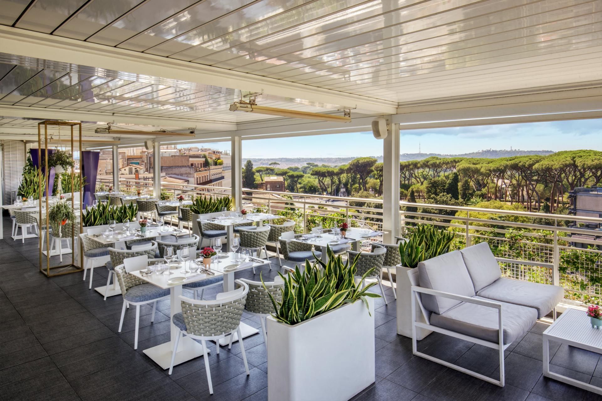 Terrazza Borghese with elegant dining tables and a view of trees and the skyline at The Tribune Hotel