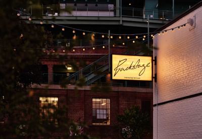 Exterior view of Backstage with sign board in The Verb Hotel at night