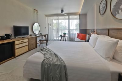 White sheeted bed and TV in a room at U Hotels
