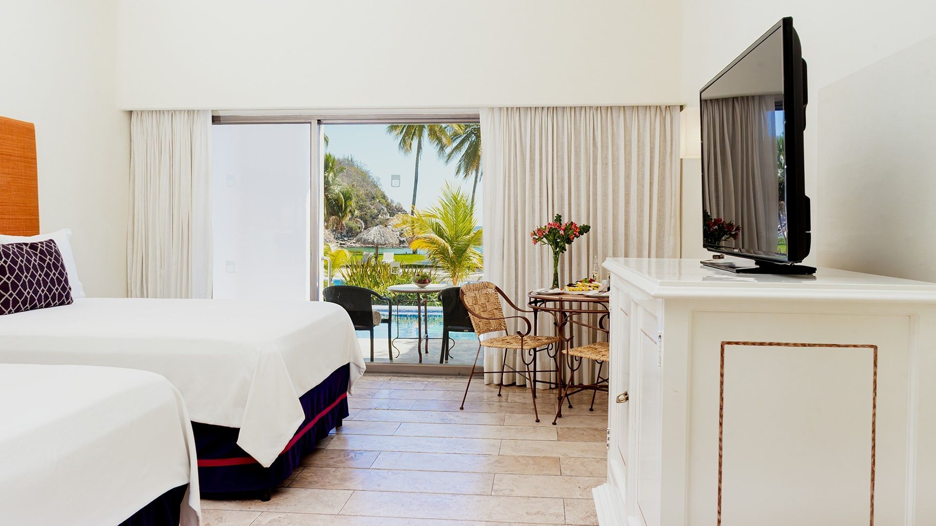 TV and dining table by the beds in Two Double Deluxe Private Pool with patio lounge area at Camino Real Zaashila Huatulco