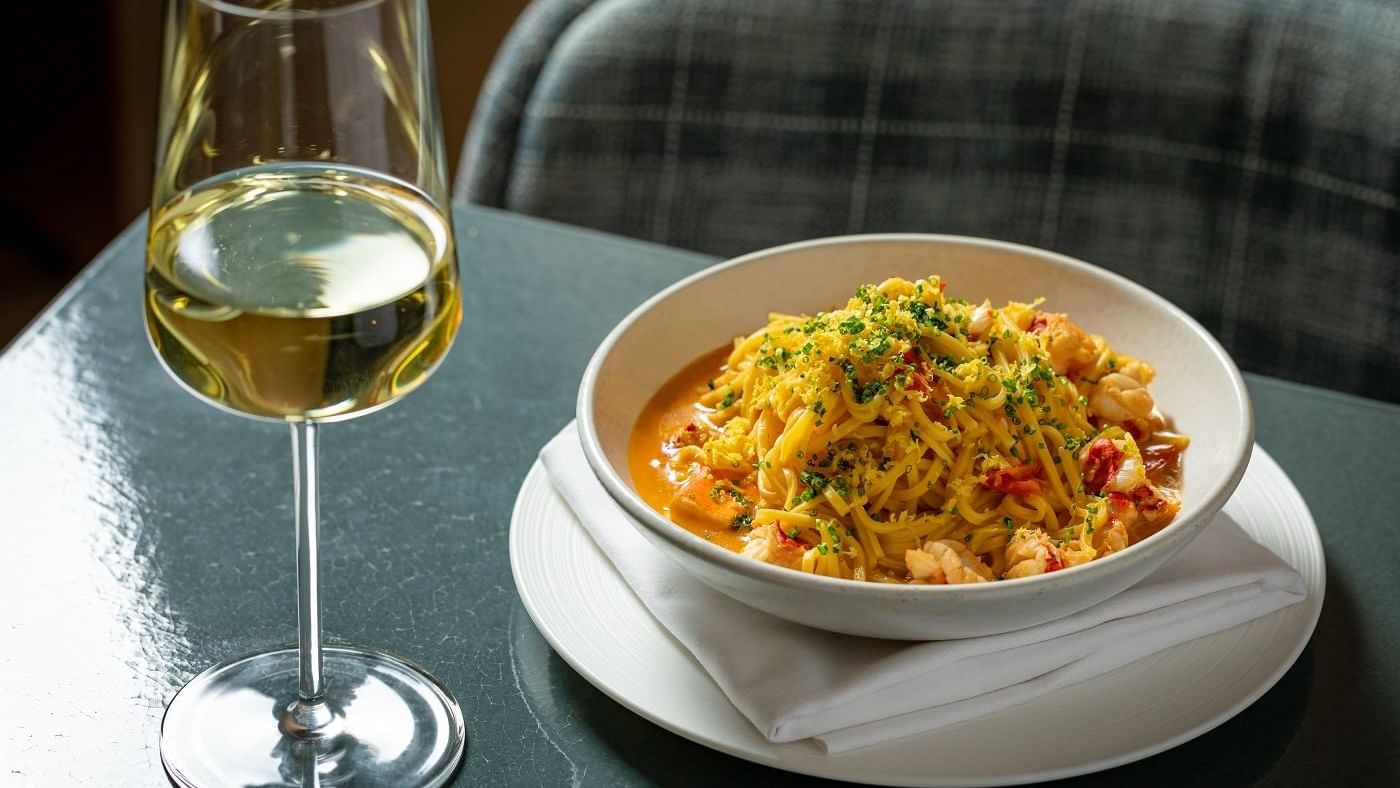 Spanish paella dish served with a glass of champagne at The Londoner Hotel