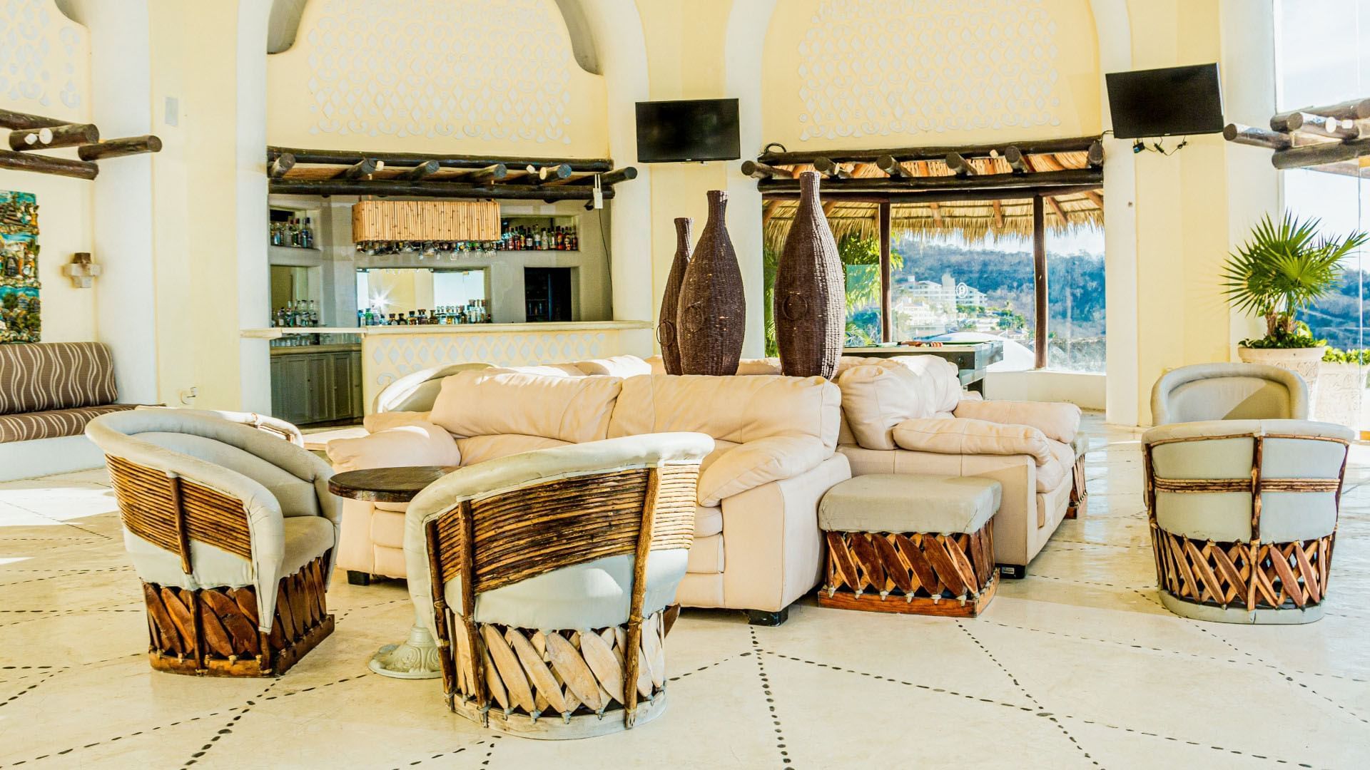 Relaxing resort lounge area with wicker chairs and a tropical view at Quinta Real Huatulco