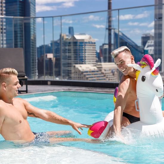 Two men enjoying in the Rooftop Pool at Pullman Sydney Hyde Park