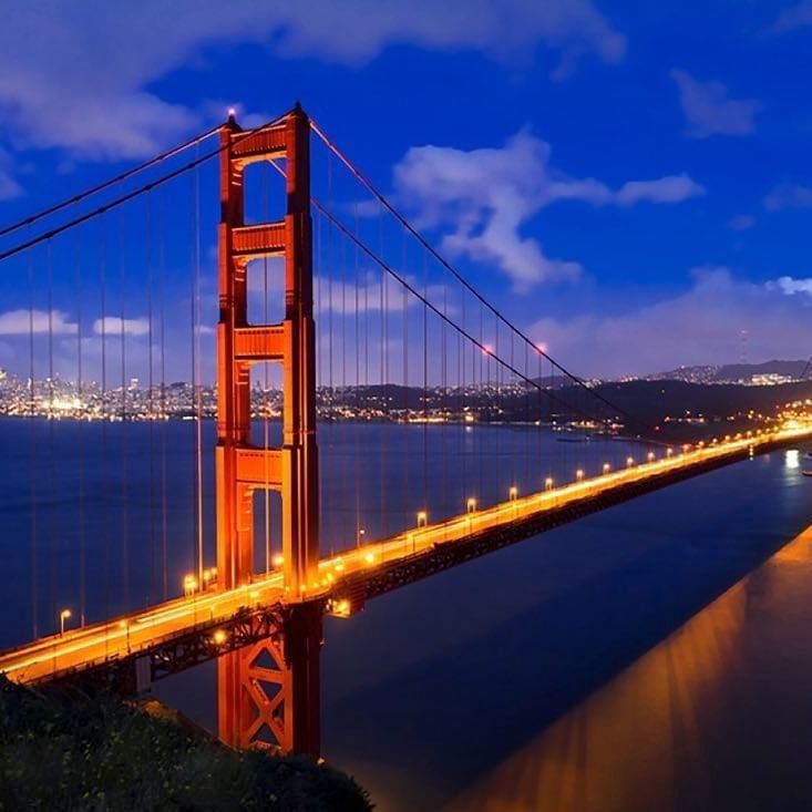 Golden Gate Bridge by city lights under a night sky near Warwick San Francisco