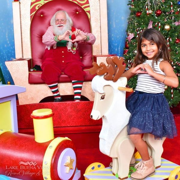 Girl posing with Santa at The Mall at Millenia near Lake Buena Vista Resort Village & Spa