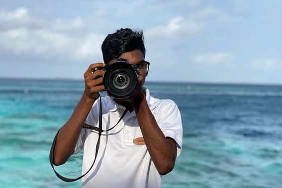 Person holding a camera by the sea at Grand Park Kodhipparu, Maldives