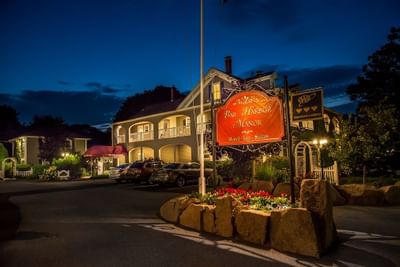 exterior of Bar Harbor Manor at night with lights from roons on