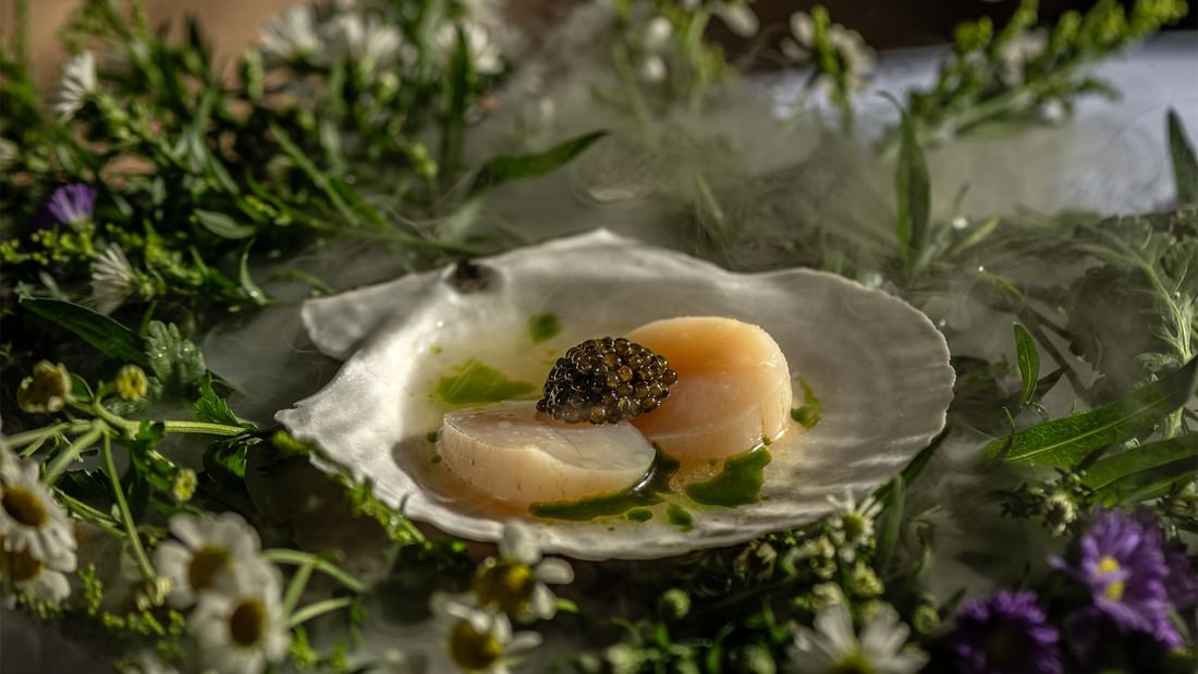 Scallop with caviar surrounded by flowers at Jeff's Cellar in Ipoh at The Banjaran Hotsprings Retreat.