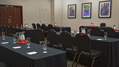 Meeting room with black tablecloths, patterned chairs, and colorful framed artwork at London Bridge Resort