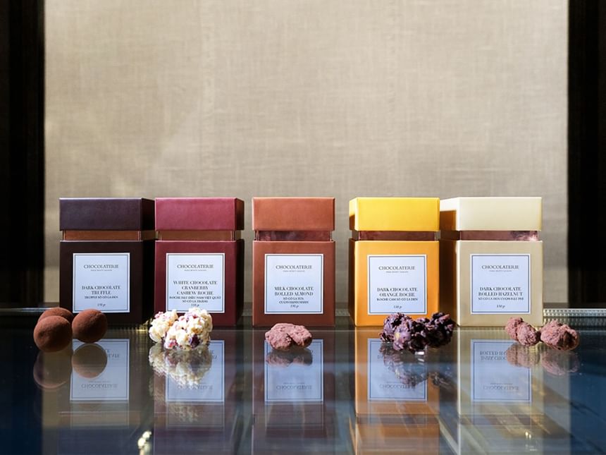 Truffle boxes and chocolate treats displayed on a reflective surface in the Chocolaterie at Park Hyatt Saigon